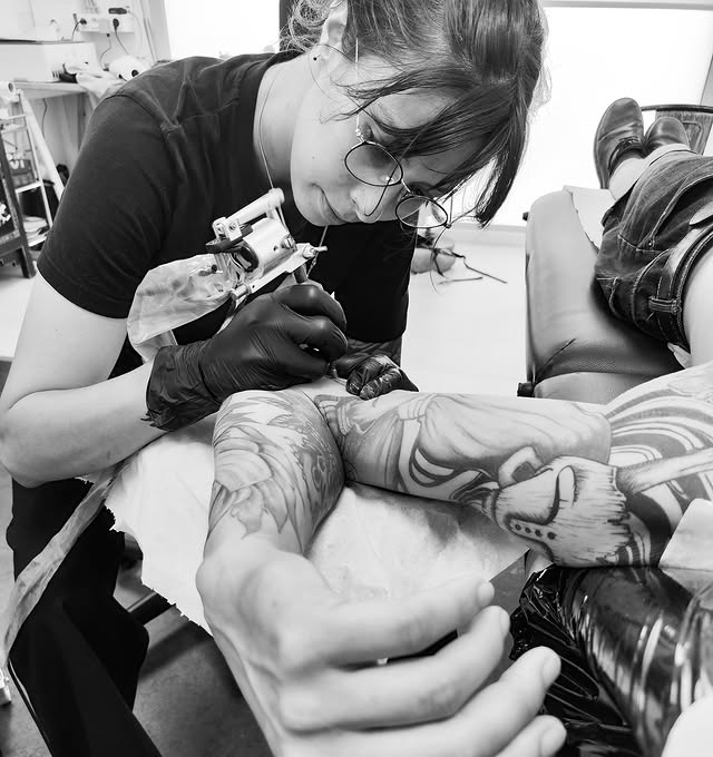 Naïdi tatouant dans son atelier