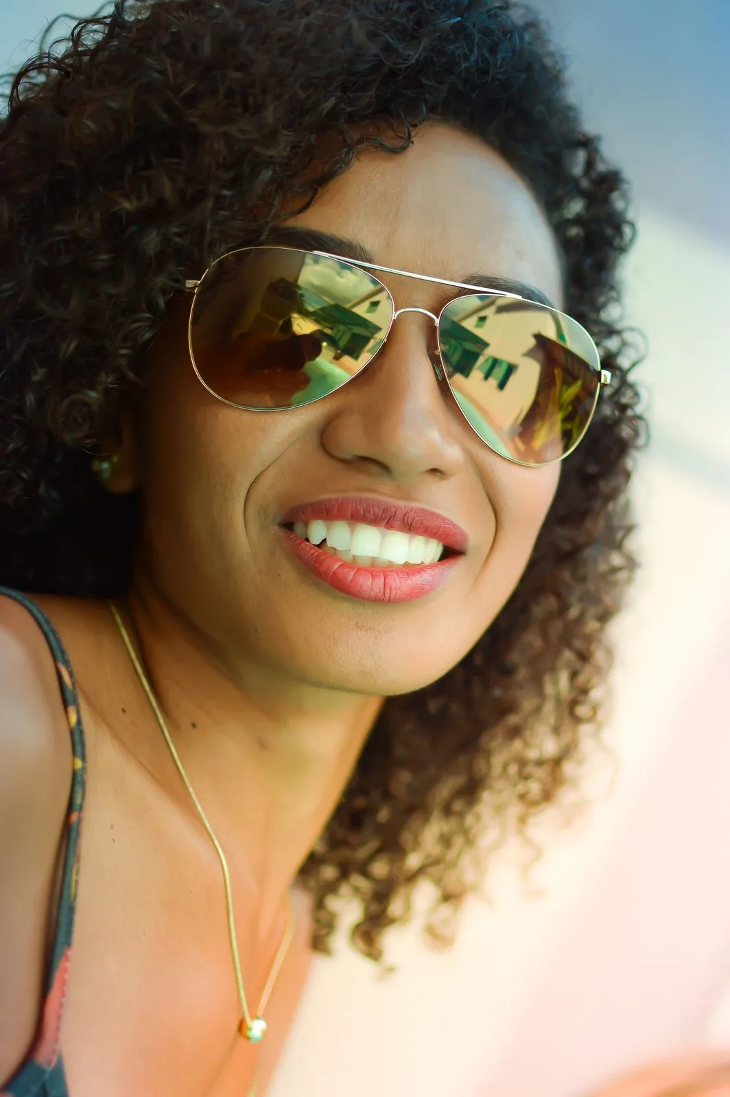Femme souriante portant des solaires aviateur miroir