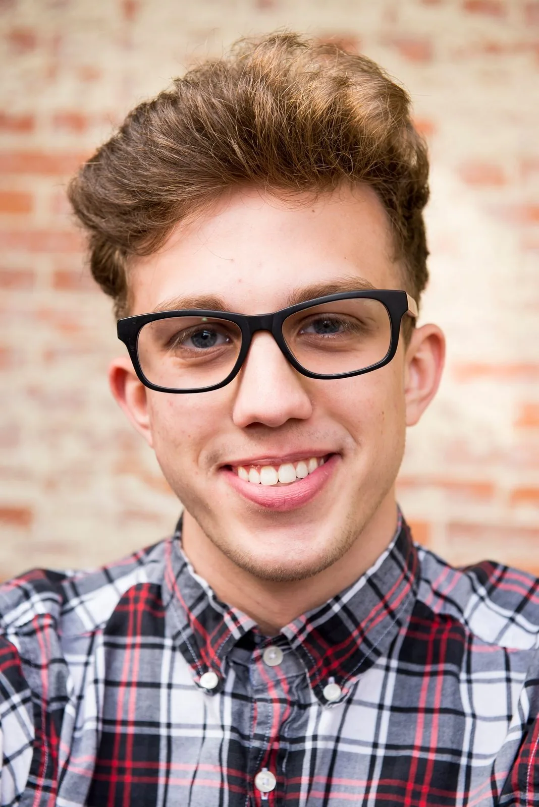 Homme souriant portant une monture noire