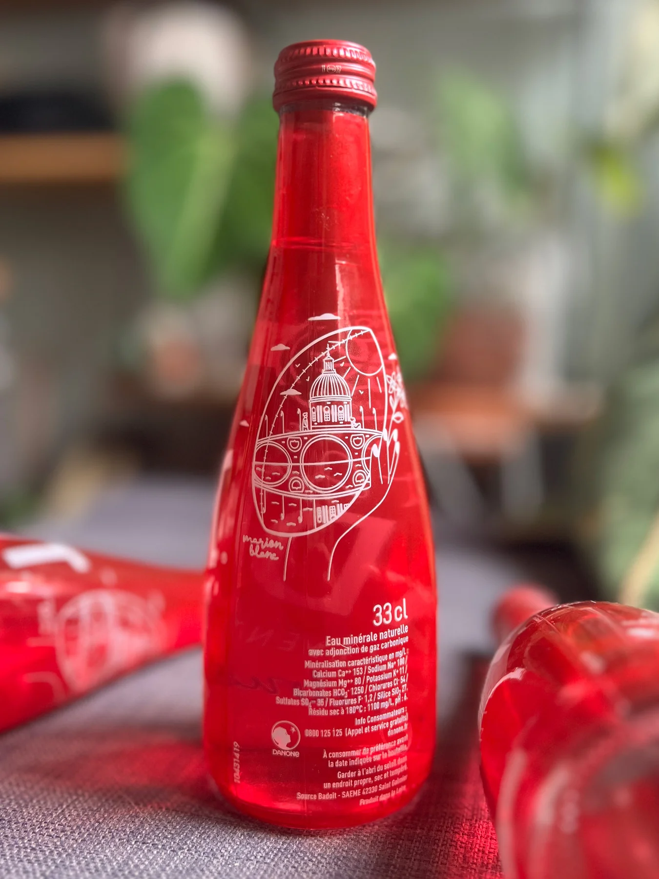 Bouteille rouge Badoit avec le décor blanc de Marion Blanc pour Toulouse